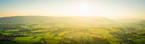 istock Aerial panorama golden light over idyllic green pasture misty mountains 818505432