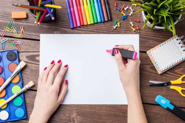 istock Woman's hand drawing on empty sheet of paper. School or art background 818505838
