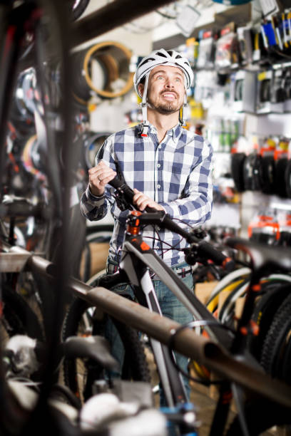istock Man in helmet chooses convenient bike 818507368