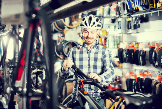 istock Man in helmet examining a selected bike 818507554
