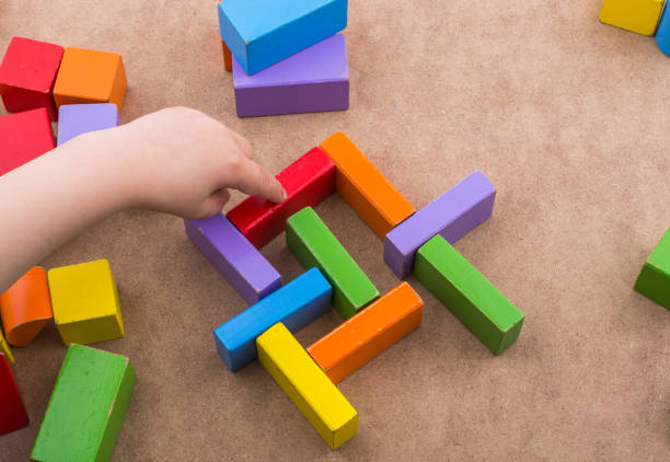 istock Toddler hand over Colorful building  blocks 818528702