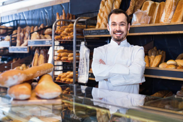 istock Man seller displaying assortment of bakery 818554618