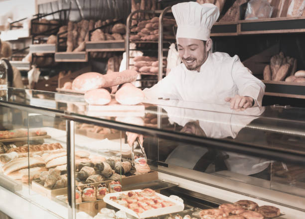 istock Cute baker showing assortment of bakery 818554708
