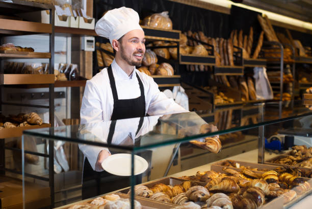 istock Male pastry maker demonstrating beautiful croissant 818556550