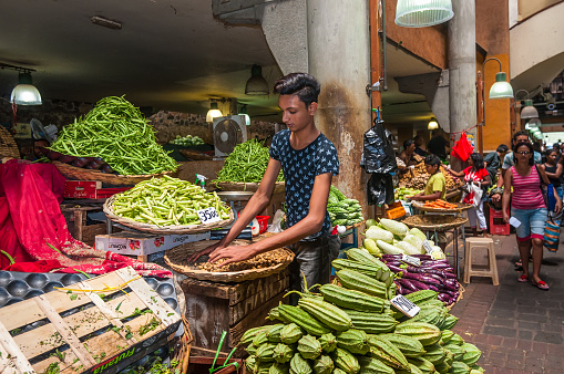 Port Louis, Mauritius - December 25, 2015: Vegetable and fruit seller on the Central Market in Port Louis, Mauritius. The Central Market is a tourist attraction and landmarks of the capital.