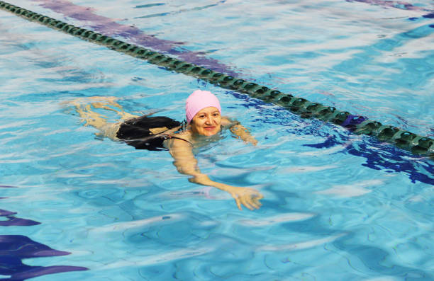 mujer nadando en la piscina de media edad - spa treatment health spa couple happiness fotografías e imágenes de stock