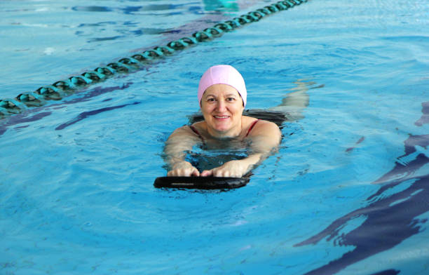 applying frau im schwimmbad - active seniors retirement enjoyment swimming pool stock-fotos und bilder