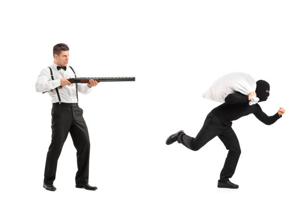istock Angry guy with rifle shooting at a burglar 818576592