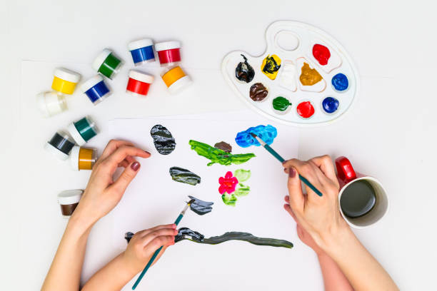 istock Child's hands painting a flower 818577604