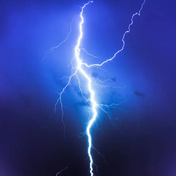 big lightning strike in thunderstorm showing electricity and high voltage of extreme weather