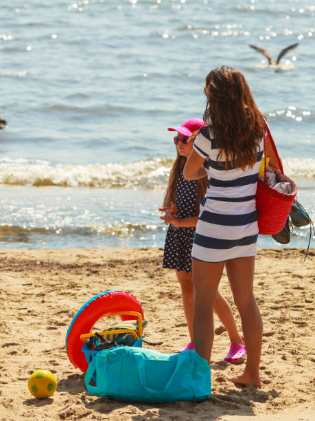 istock Mother and daughter playing on beach. 818609694