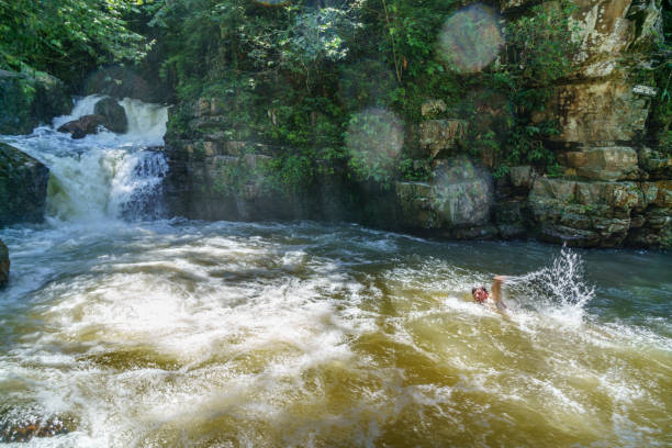 Brazilian man swimming in fast flowing river