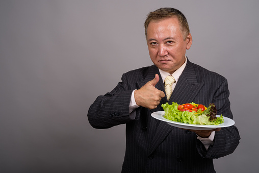 Shot of an humorous overweight man lifting dumbbells