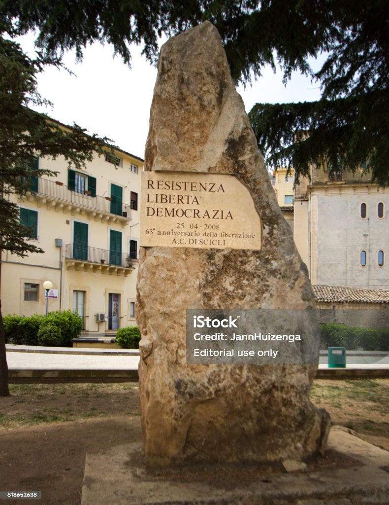 Scicli, Sicily: WWII Memorial Plaque on Tree Scicli, Sicily: WWII memorial plaque posted on a tree in a piazza in downtown Scicli: “Resistance, Liberty, Democracy.” The plaque was posted in 2008 to commemorate the 63rd anniversary of Italy’s liberation in WWII. Scicli, in Ragusa Province, is a UNESCO World Heritage Site. Allied Forces Stock Photo