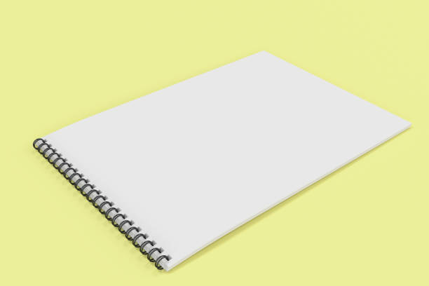 istock Blank white notebook with black spiral bound on yellow background 818654696
