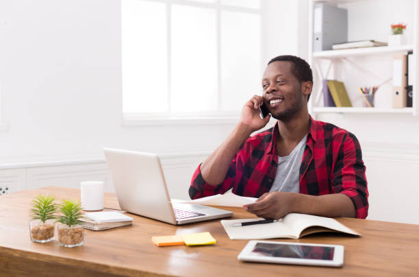 istock Young black businessman call mobile phone in modern white office 818655770
