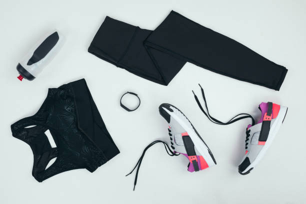 flat lay with sportswear with sneakers, fitness tracker and sports bottle isolated on grey flat lay with sportswear with sneakers, fitness tracker and sports bottle isolated on grey sports clothing stock pictures, royalty-free photos & images