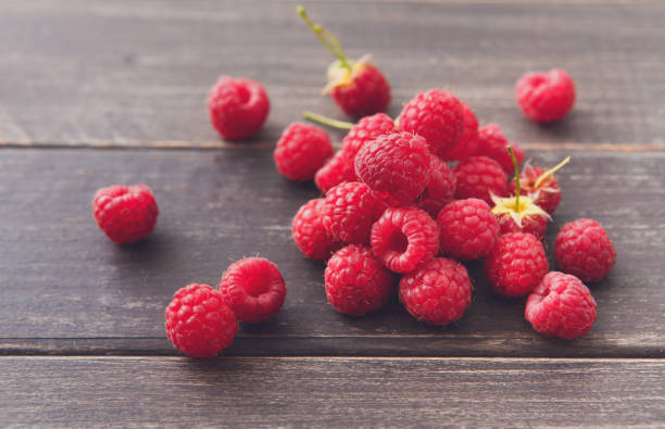 istock Fresh raspberries closeup on wood background 818722986