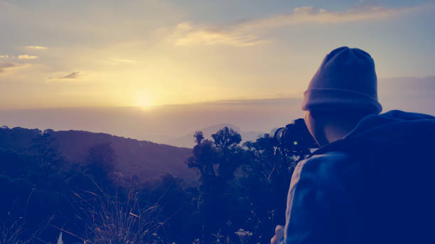 istock Male backpacker taking photograph at sunset in morning. 818764208