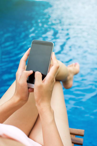 istock Girl using phone by the swimming pool 818780802