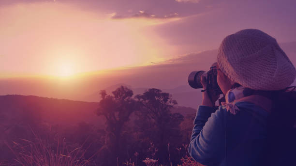 istock Female backpacker taking photograph at sunset in morning. 818816402