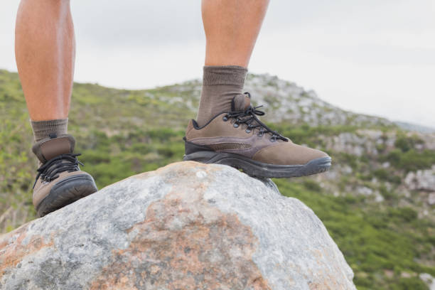 istock Low section of man on rock against mountain terrain 818831618