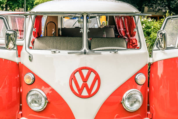 1950s Volkswagen Transporter T1 campervan with open doors parked in a park. The Volkswagen Transporter is a popular van to use as a camper and was delivered originally as a camper van, but many have been converted later.