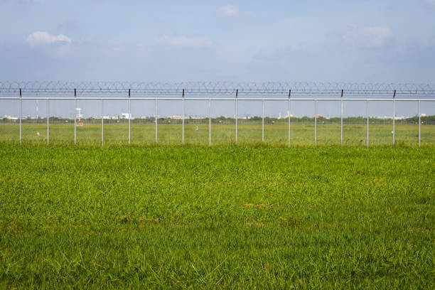 green field and barbed wire fence in jail or security zone