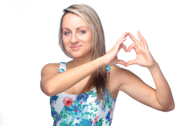 istock pretty young woman making heart sign on white 818866650
