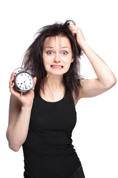 stressed young woman with clock on white stock photo