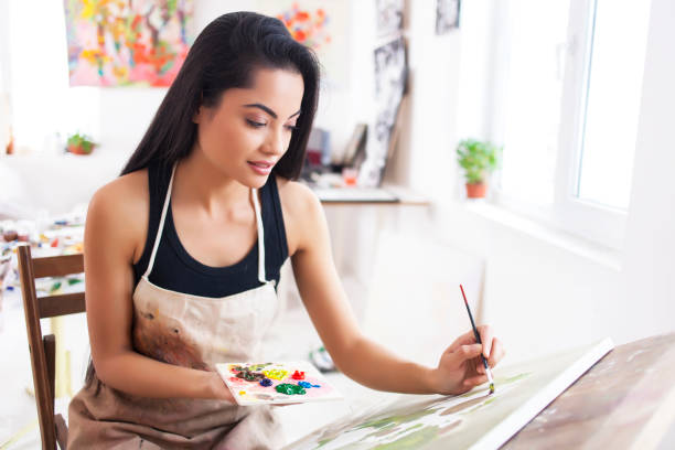 Smiling female artist drawing in studio