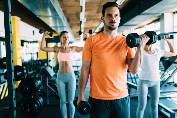 istock Young attractive man doing exercises in gym 818874448