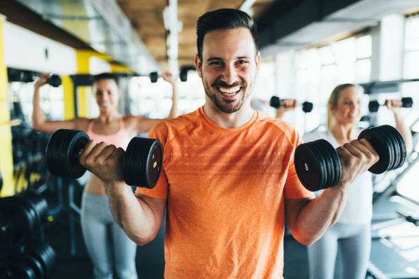 Group of friends exercising together in gym Group of friends exercising together in gym with dumbbells lift weights stock pictures, royalty-free photos & images