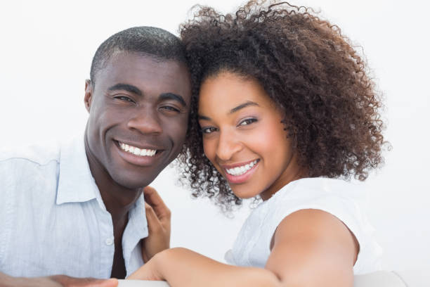 istock Couple sitting on couch together smiling at camera 818875434