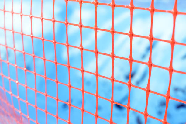 istock Plastic safety net for construction site. Construction mesh on winter snow background 818881590