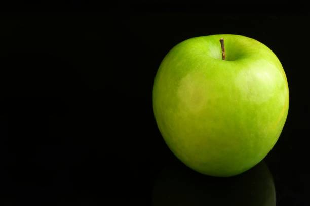 istock A fresh Granny Smith apple on a black background. 818914450