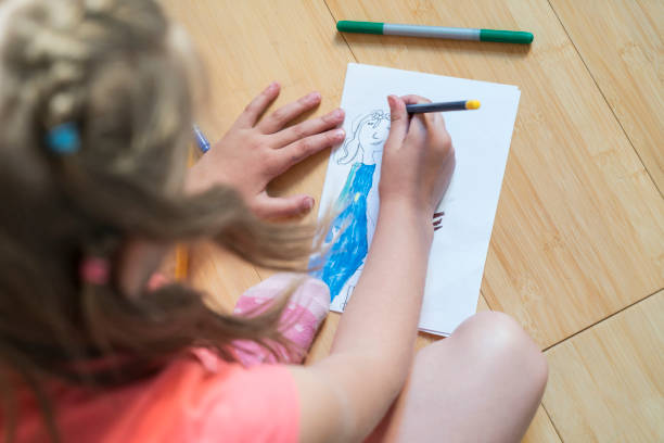 istock Girl drawing on paper 818924624