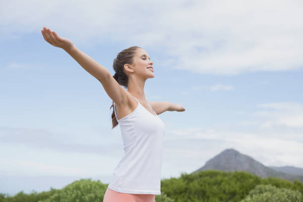 istock Beautiful woman with arms raised against sky 818963310