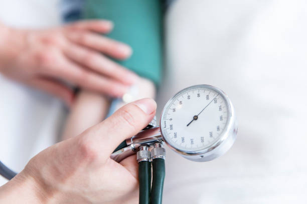 Nurse taking blood pressure of patient stock photo