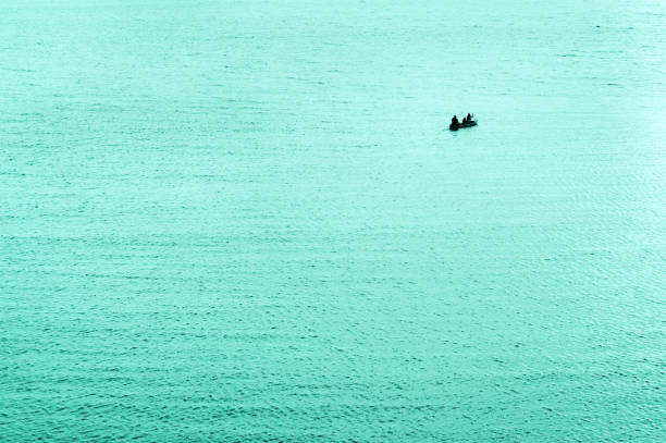 Going on adventure, canoe silhouette on turquoise water.