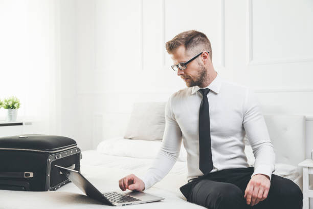 istock Businessman working from a hotel room with his laptop 819092804