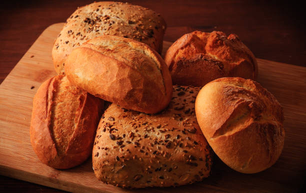 istock Wheat rolls and multigrain rolls on a wooden board and a brown table 819094010