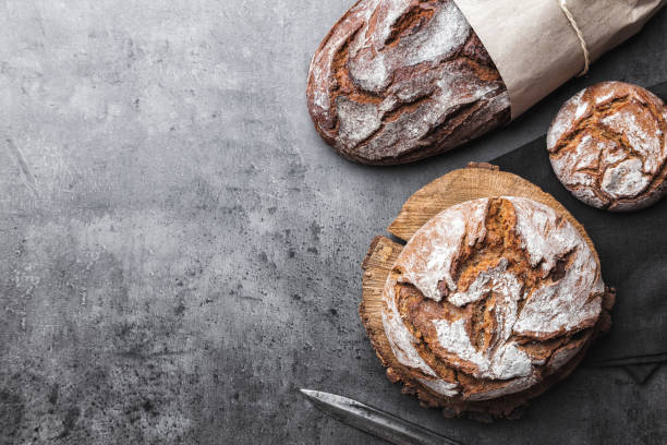 delicious fresh bread on rustic background - pão fresco imagens e fotografias de stock