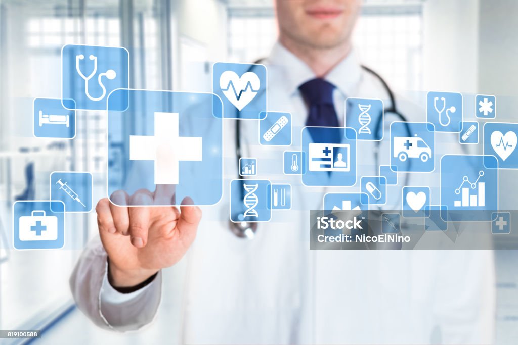 Medical doctor showing icons of healthcare services, hospital background Medical doctor showing icons of health care services (cross, heart, DNA, insurance card, ambulance symbols) on a digital screen with hospital interior in background Medical Insurance Stock Photo