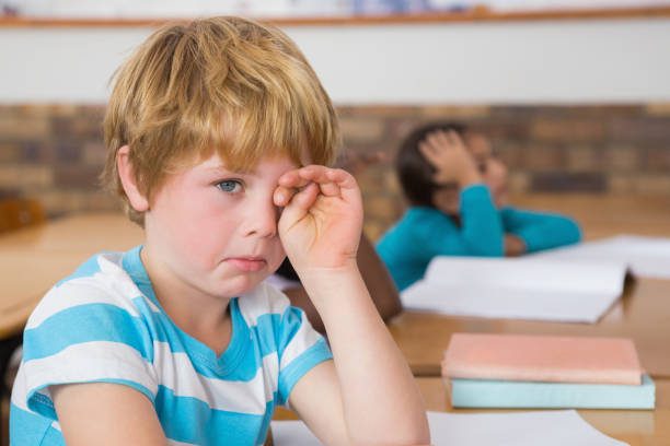 istock Upset pupil sitting at his desk 819143242