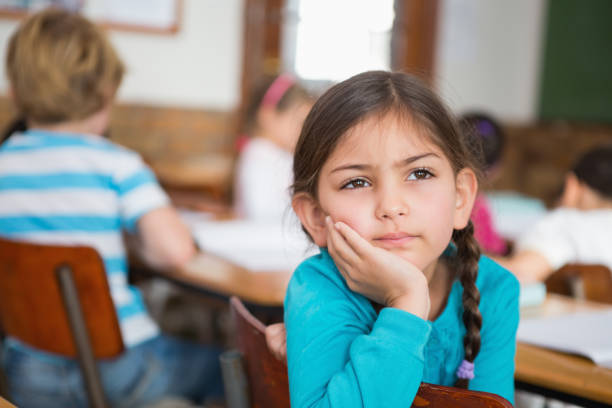 istock Thoughtful pupil sitting at her desk 819145294