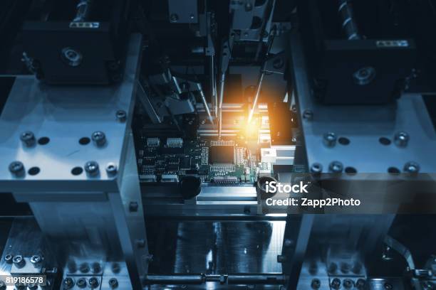Selective Focus To Pcb Circuit Board Automation Of Machine Industry Assembly Of Computer Circuit Board In Smart Factory For Production Computer Components Blue Tone With Flare Light Stock Photo - Download Image Now