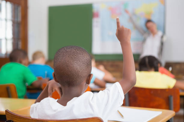 istock Pupil raising hand in classroom 819187922