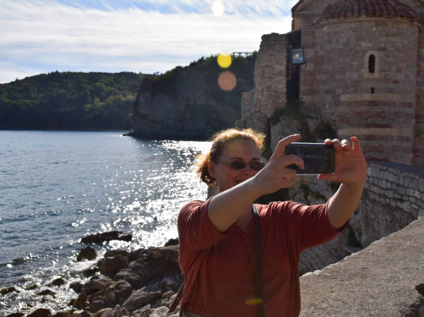 woman take a selfie on the seashore - beach stone wall one person imagens e fotografias de stock