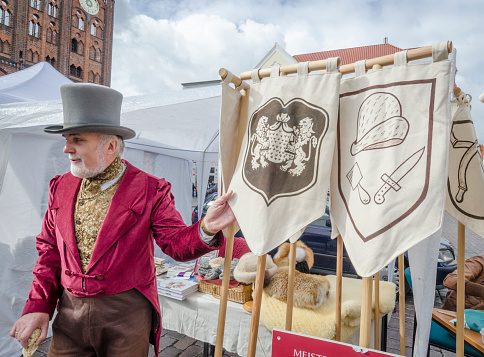 Craft market trader in traditional German costume, Stralsund, Germany